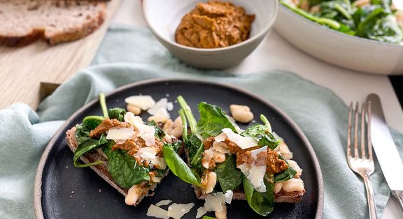 Tomatenpesto auf warmer Bohnen-Spinatpfanne und Sauerteigbrot