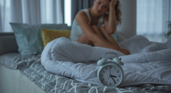 Frau kann nicht schlafen und schaut auf eine Uhr die halb 4 anzeigt Frau kann nicht schlafen und schaut auf eine Uhr die halb 4 anzeigt